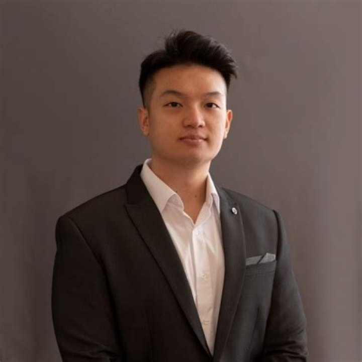 Wayne Liang posing by his car